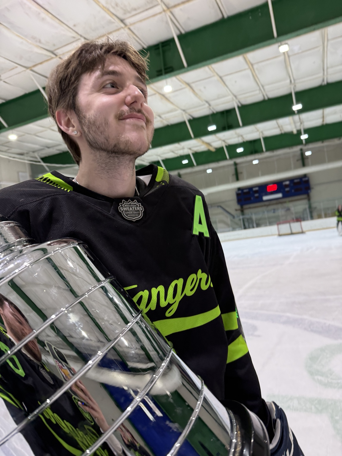 A Strangers alternate captain holds the championship trophy on the ice.